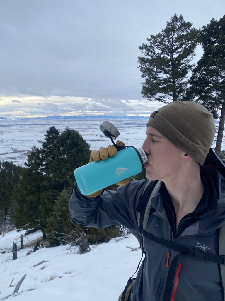 Reviewer drinks from a Hydro Flask on a hike.